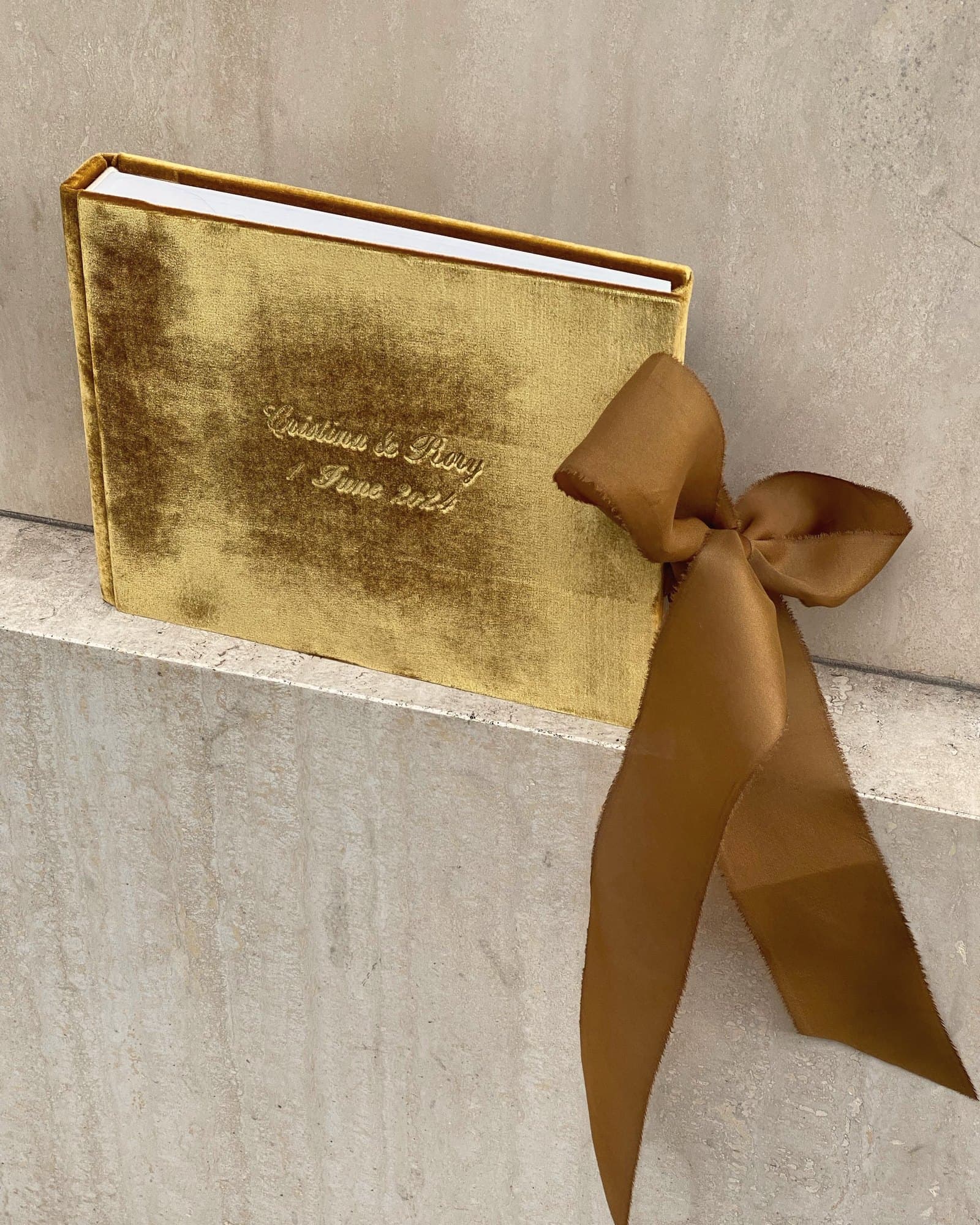 Gold velvet book-style box tied with a bronze satin ribbon